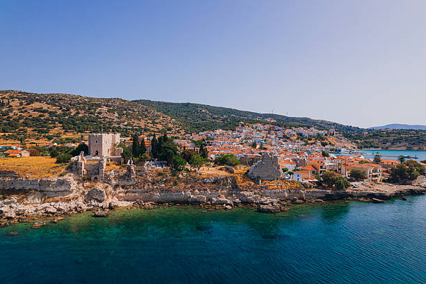 Colorful waterfront houses and traditional harbor views in Pythagoreio, a historic coastal town on Samos Island in the Aegean Sea, Greece. Clear summer skies, calm waters, and Mediterranean architecture reflect the island’s cultural heritage and relaxed seaside atmosphere.