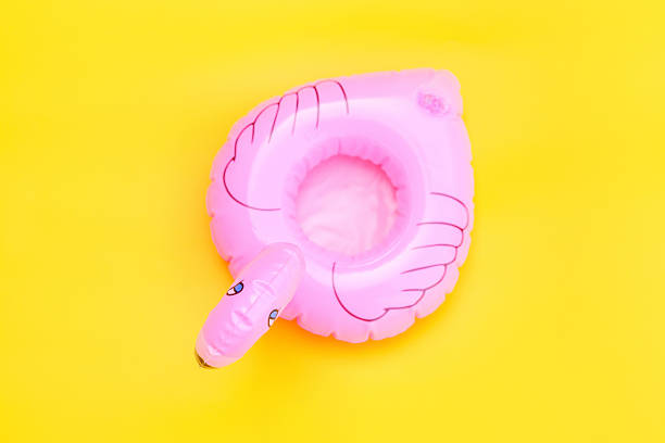 istock Summer beach composition. Simply minimal design with pink Inflatable flamingo isolated on yellow background. Pool float party, trendy celebrity fashion concept. Flat lay top view copy space. 2257646074