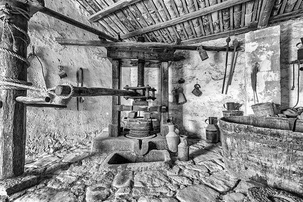 Black and White Interior of a Rustic Historical Stone Cellar with an Ancient Wooden Olive Oil Press