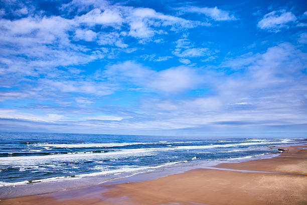 Tranquil Oregon beachscape with vast sky, calm ocean, and serene sandy shore. Perfect for themes of solitude, natural beauty, and reflection. Ideal for travel, wellness, or nature-focused projects.