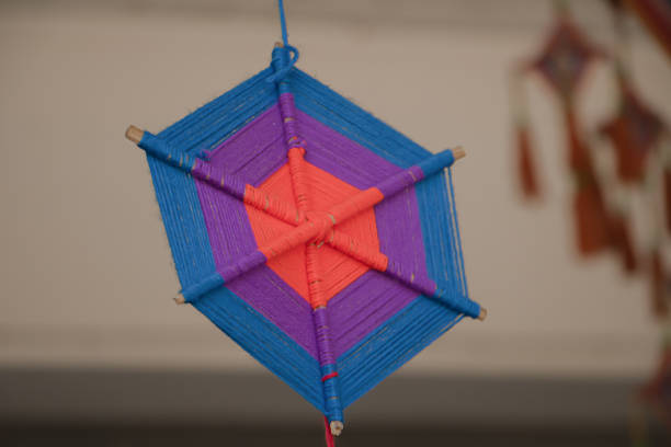 Handmade colorful yarn mandala wall hanging with geometric pattern, traditional craft decoration, soft focus background.