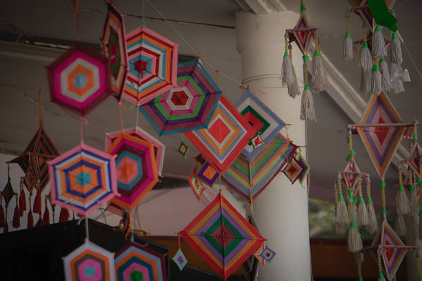 Colorful handmade yarn mandala decorations hanging indoors, geometric patterns, traditional folk craft, bohemian style, soft natural light.