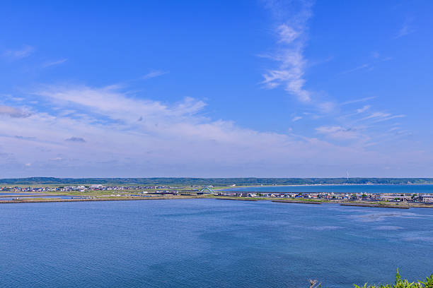 Wide coastal view from Cape Azechi in Hamanaka Town, eastern Hokkaido. Includes Kenbotsukito Island, small islets, the Pacific Ocean, and the surrounding nature under a clear blue summer sky.