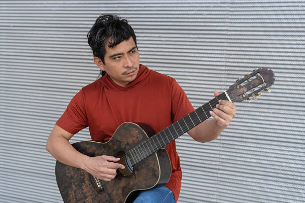 Indigenous man playing guitar, focusing on musical expression and cultural identity