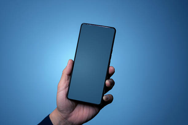 Closeup hand holding a modern smartphone with empty screen on blue gradient background, ideal for app UI presentation, mobile advertising, branding, and digital marketing mockups.