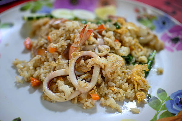 Seafood Fried Rice or Nasi Goreng mixed with squid, prawn and egg served on white plate
