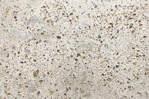 istock Concrete surface texture with exposed aggregate stones. Light beige cement background closeup. 2257714022