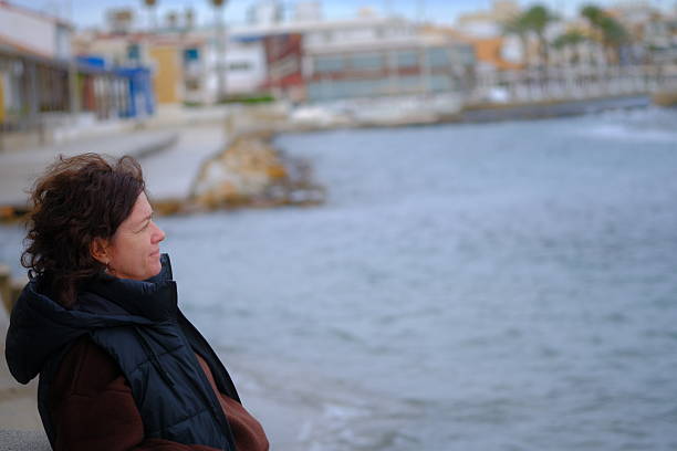 Woman on the beach at sunset, a winter day with calm, blue water