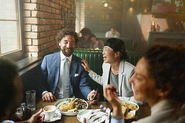 Cheerful business team having fun while talking during a meal in a restaurant.