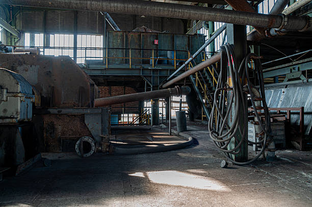 An old abandoned industrial hall from the mining era, showing rusted steel, broken windows, and decaying machinery, symbolizing industrial heritage, decline, and the passage of time.