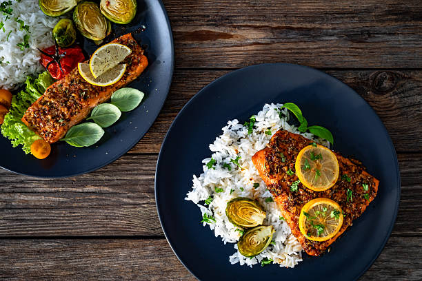 Baked salmon with white rice on wooden table