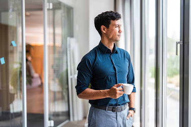 istock Asian Businessman Reflecting in Office with Coffee 2257725824