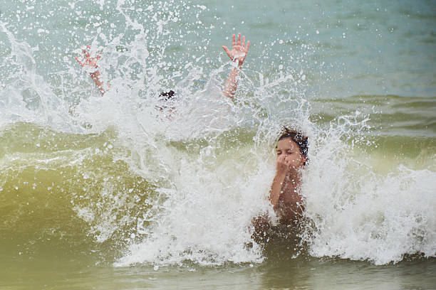 Happy boy run from the shore into the water. Summer childrens vacation on shore of lake or river. kid jump into water, swim and splash around at sunset. Active holidays. Dynamic image. Selective focus