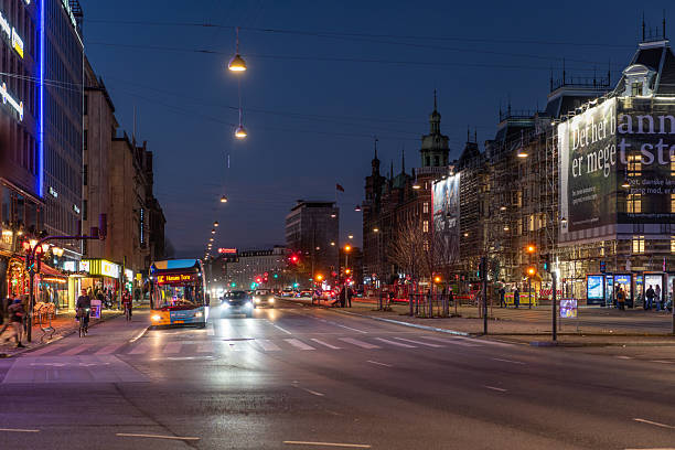 28 december 2025, Copenhagen, Denmark. H. C. Andersens Boulevard during night. Illuminated facades, busy traffic during evening. Pedestrians on sidewalk. Bustling city during night.