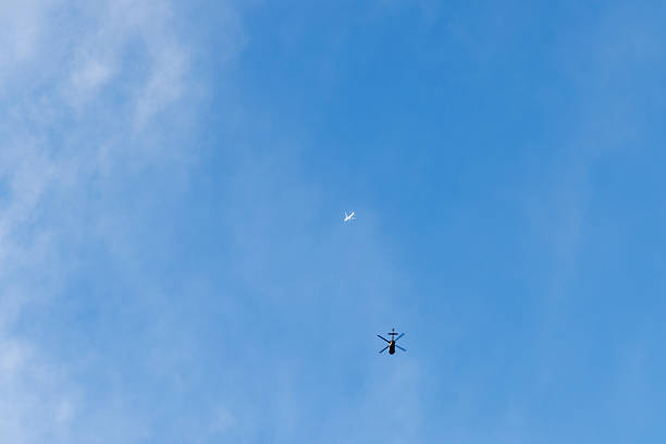 A Helicopter Soars High Above the North Sea Under Clear Blue Sky, Capturing the Essence of Aerial Exploration on a Sunny Day. This Scene Highlights the Connection Between Nature and Technology.
