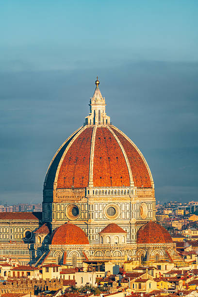 Brunelleschi's Dome of the Cathedral of Santa Maria del Fiore in Florence, Italy, standing prominently over historic city buildings at sunset