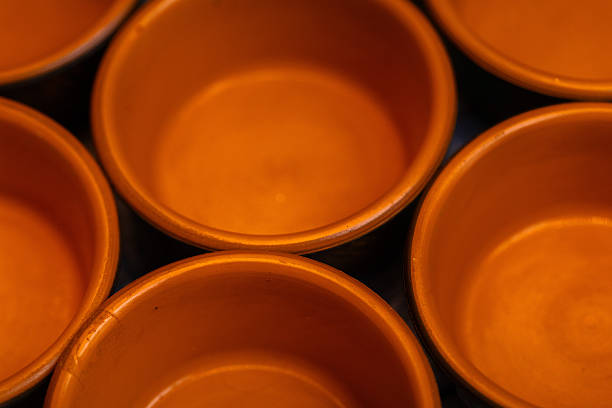 Clay ceramic background with handcrafted pottery plates and natural earthy textures. Traditional handmade ceramics with rustic style, ideal for culinary concepts, traditional cuisine, folk art, home decor, craftsmanship, and cultural heritage backgrounds.