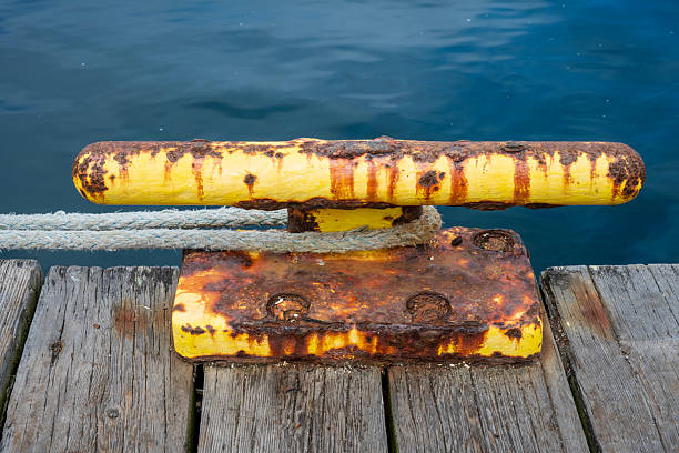 Rope on weathered nautical cleat on pier deck, Port Angeles, Washington, USA