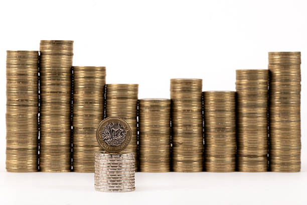A conceptual image of the British pound, featuring a 1 pound coin against a backdrop of stacks of coins.