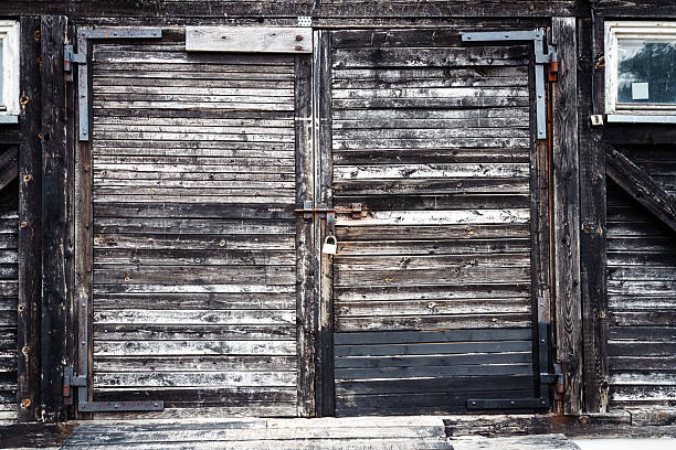Old gray wooden plank gates with padlock. Architectural detail.