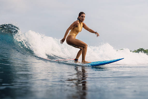 Female surfer on surfboard during surfing. Surfer woman on ocean wave