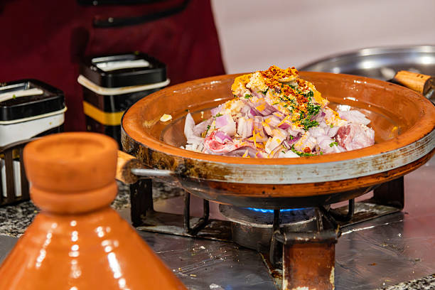 A vibrant Moroccan kitchen scene featuring clay tagine steaming on a gas stove