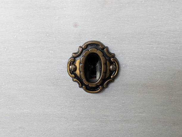 Close up of an old fashioned key stuck in a white key hole