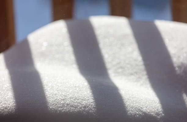 Shadows of wooden railing on snow surface
