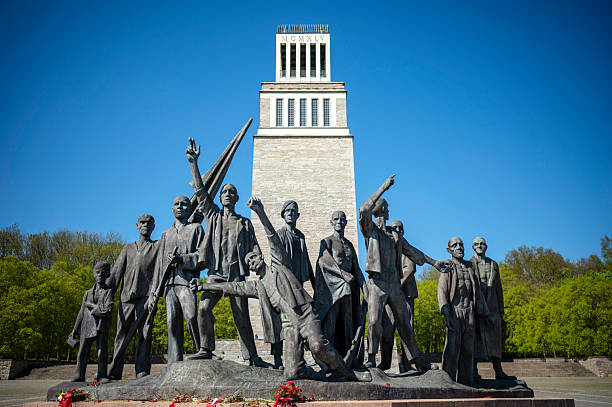 Weimar, Germany - April 27, 2025: The bell tower of the Buchenwald National Memorial and the group of figures created by Fritz Cremer, which commemorates the victims of National Socialism at the memorial site of the former Buchenwald concentration camp on the Ettersberg. The bronze sculpture is dedicated to the victorious resistance struggle in the former concentration camp and depicts the self-liberation of the prisoners under the leadership of the communists.