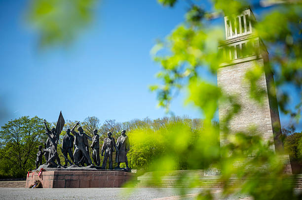 Weimar, Germany - April 27, 2025: The bell tower of the Buchenwald National Memorial and the group of figures created by Fritz Cremer, which commemorates the victims of National Socialism at the memorial site of the former Buchenwald concentration camp on the Ettersberg. The bronze sculpture is dedicated to the victorious resistance struggle in the former concentration camp and depicts the self-liberation of the prisoners under the leadership of the communists.
