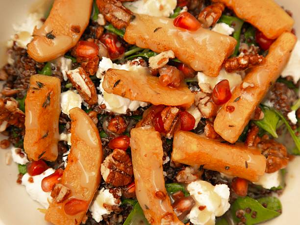 quinoa bowl topped with roasted pumpkin slices, creamy feta cheese, crunchy toasted pecans, fresh spinach, and ruby pomegranate seeds, finished with a light honey vinaigrette.