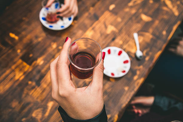 Woman holding traditional Turkish tea in Istanbul, Turkey