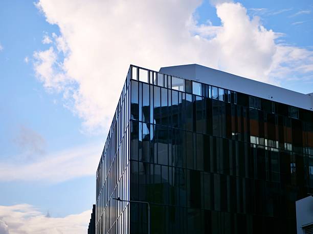 modern architecture office building exterior glass facade reflecting sky clouds urbandesign corporate headquarters contemporary structure windows