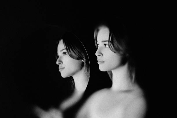 Woman contemplating her reflection, representing self-discovery and inner beauty