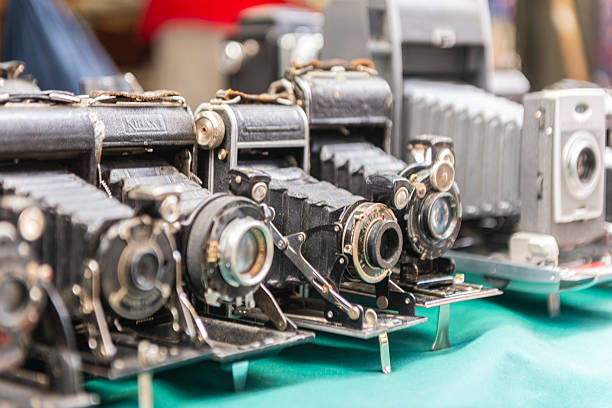 Vintage film cameras are displayed at an antiques market, captured with selective focus highlighting classic photography equipment.