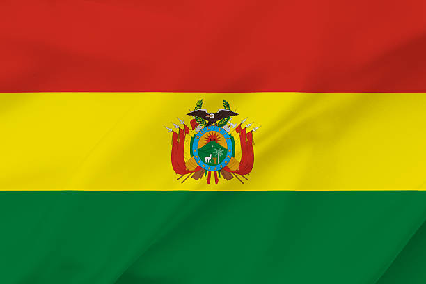 Bolivia national flag waving textile background with red yellow and green horizontal bands and coat of arms in the center