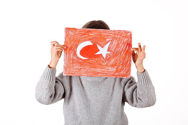 Happy young girl in a white t-shirt proudly holds the Turkish flag. National pride and celebration theme.