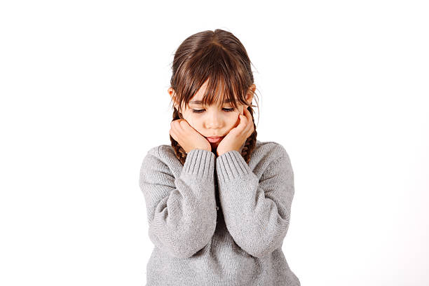 Studio portrait unhappy girl with long hair isolated on neutral background, upset child looking into camera with sad eyes