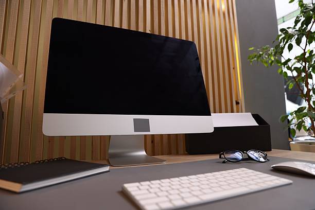 Modern computer, notebook and glasses on desk in office, closeup. Comfortable workplace