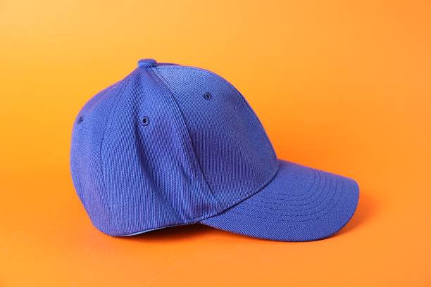 One blue baseball cap on orange background, closeup. Mockup for design