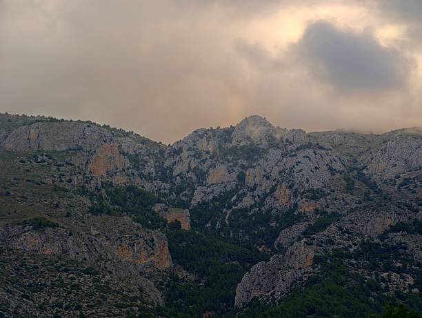 Dusk Canyon Corridor Under Warm Cloud Cover, Narrow Gorge With Layered Cliffs And Shaded Pathways Leading Into