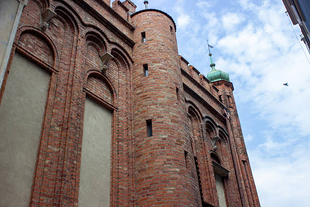 Gdansk, Poland. June 07, 2019. View of historic brick defensive architecture with medieval tower and gothic details against cloudy sky in old town.