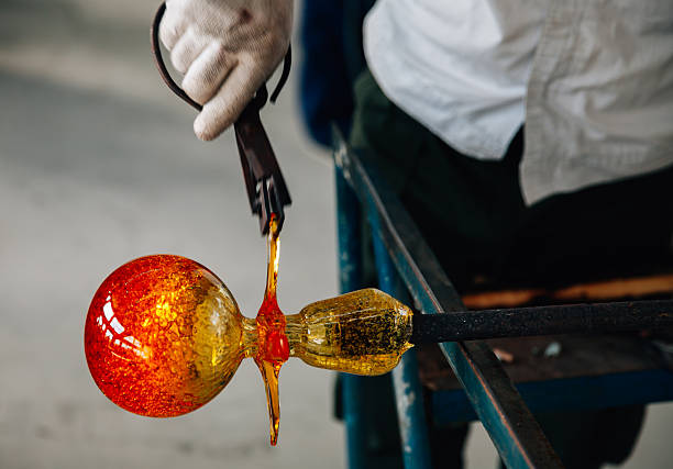 Traditional glassblowing worker making glass crafts
