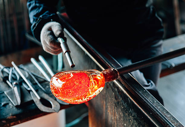 Traditional glassblowing worker making glass crafts