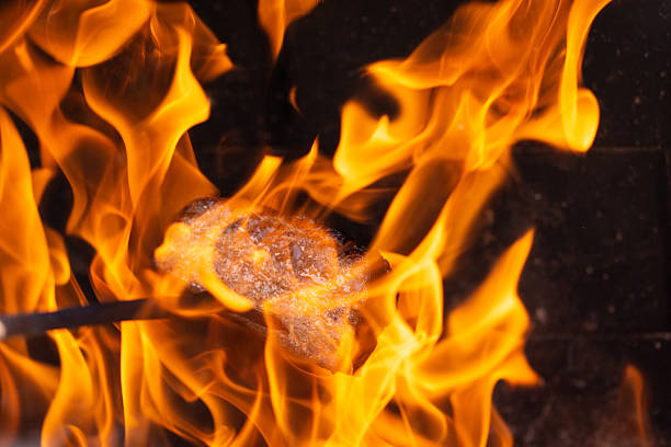 Burning wood on the grill for further cooking meat over coals