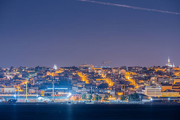 Lisbon Portugal December 24 2025. Historic towers and dense hillside residential buildings form a layered skyline illuminated at night.
