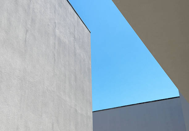 istock Abstract view of modern white walls with strong angular lines cutting into a clear blue sky. 2257897841