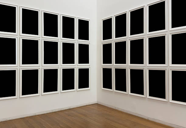 Modern art gallery interior with multiple empty black frames on white walls. Minimalist exhibition concept with repetition and symmetry, displayed in a contemporary museum space with wooden floor.