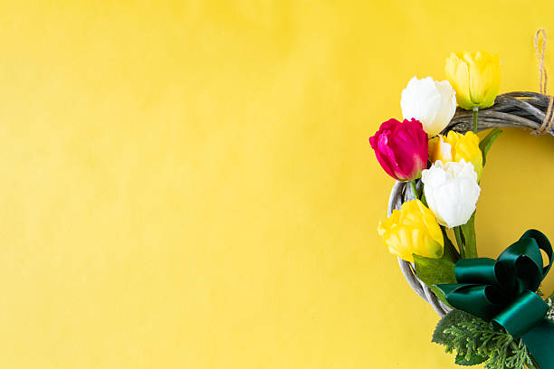 Colorful tulip wreath with yellow background.