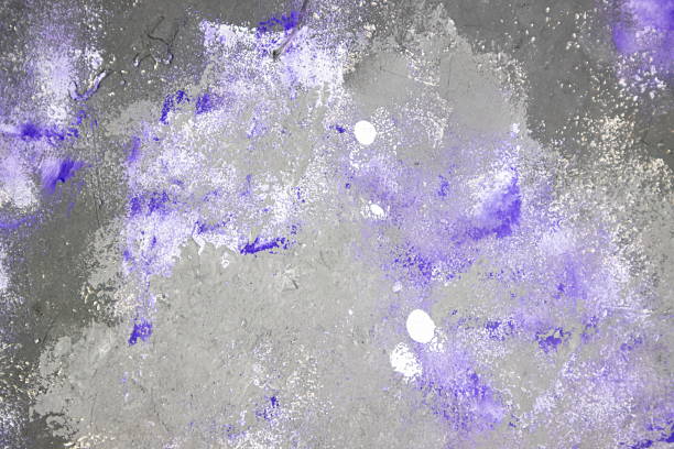 An abstract design features a gray surface covered with splashes of purple and white. This artwork combines various textures for visual interest and creativity.